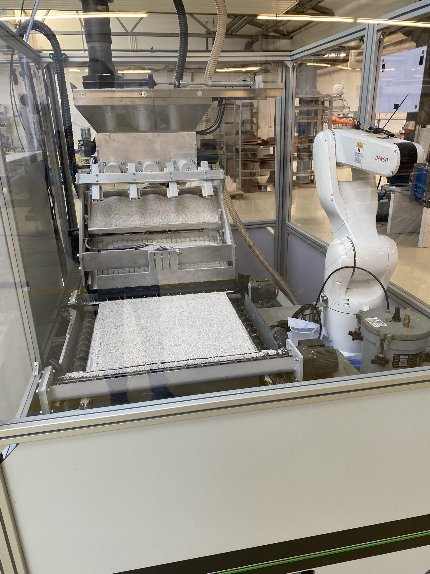 Pulverbett mit Rakelsystem und Denso-Roboterarm